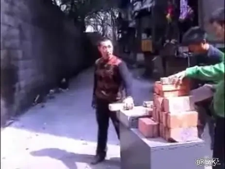 Muncitorul Bruce Lee! Sparge caramizi cu mana la foc automat - vezi VIDEO!