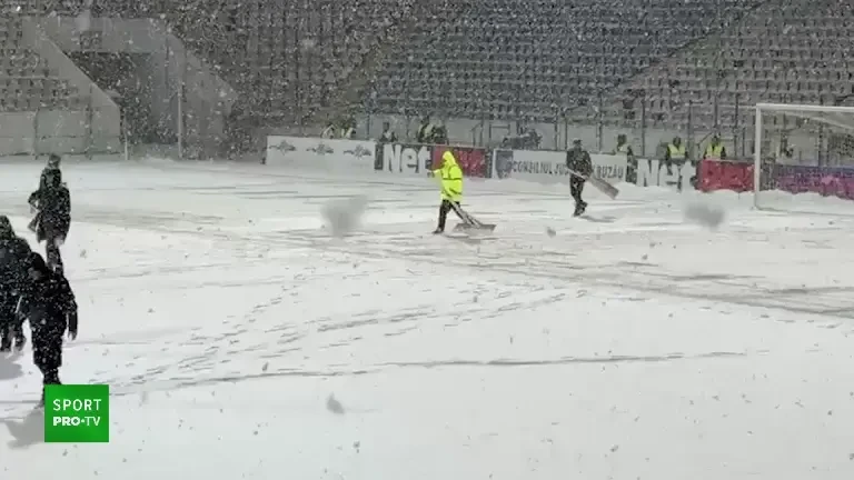 Pe stadionul de la Buzău, zăpada se îndepărtează de pe gazon cu... banca :)